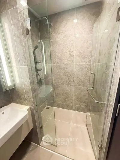 Modern bathroom with glass shower enclosure and sleek tile design