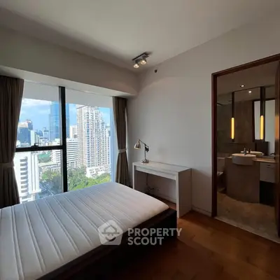 Modern bedroom with city view and ensuite bathroom in high-rise apartment