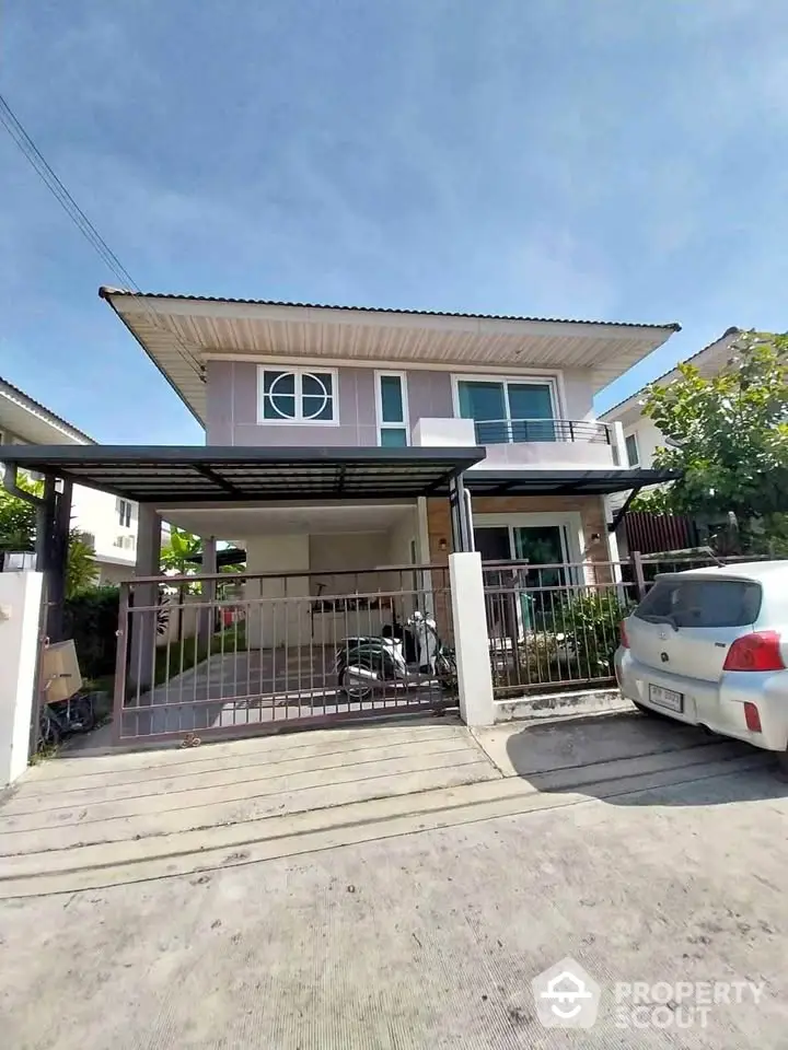 Modern two-story house with carport and driveway in sunny suburban neighborhood.