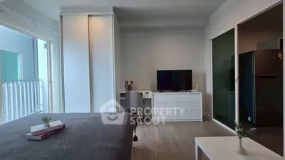 Modern bedroom with balcony access and sleek furniture in a stylish apartment.