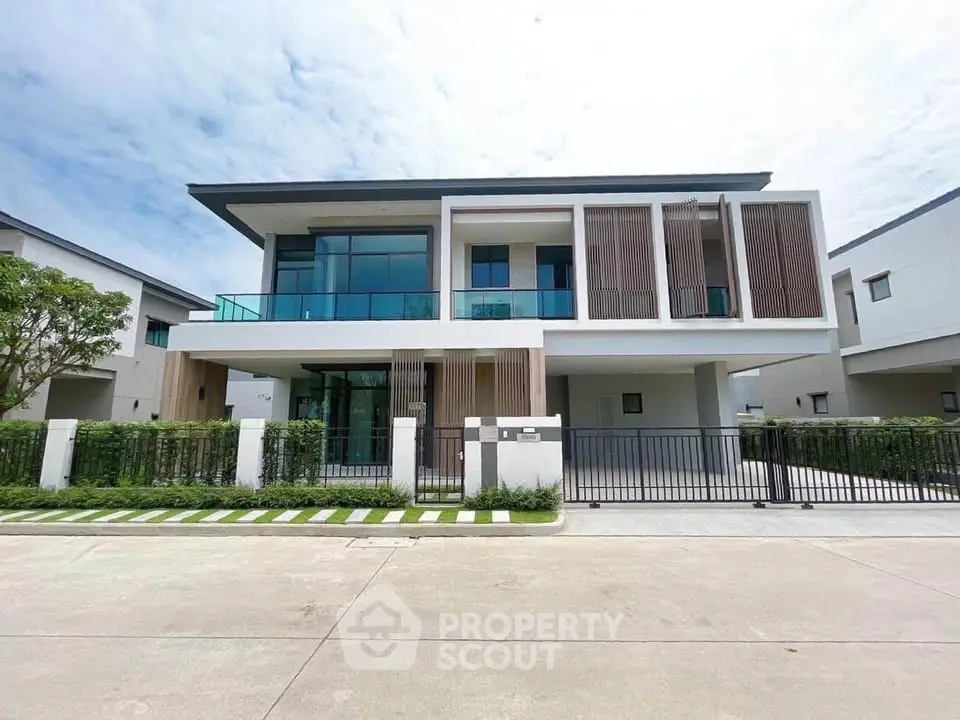 Modern two-story house with sleek design and large windows in a suburban neighborhood.