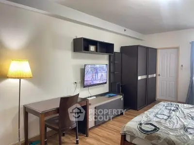 Cozy bedroom with modern furniture and wall-mounted TV, perfect for relaxation and entertainment.