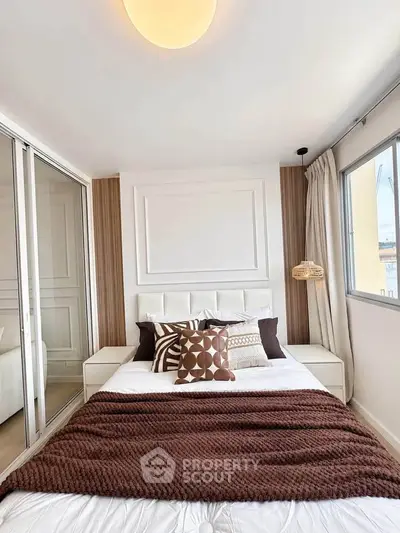 Modern bedroom with stylish decor and ample natural light, featuring a cozy bed and elegant design elements.
