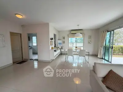 Spacious modern living room with dining area and large windows for natural light.