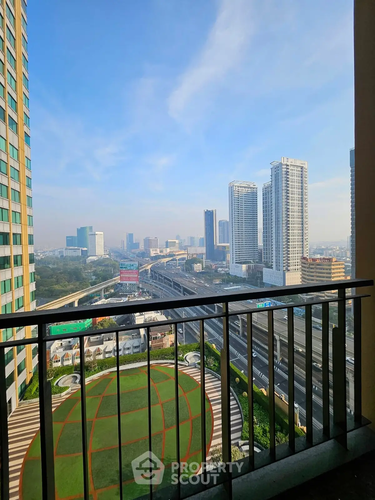 Stunning urban view from high-rise balcony overlooking city skyline and highway.