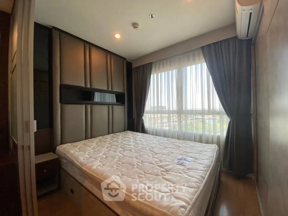 Cozy bedroom with large window and modern design in a stylish apartment.