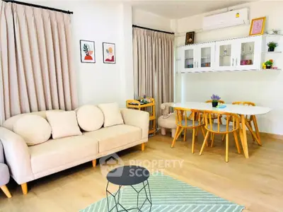 Charming living room with modern decor and dining area, featuring cozy sofa and stylish furniture.