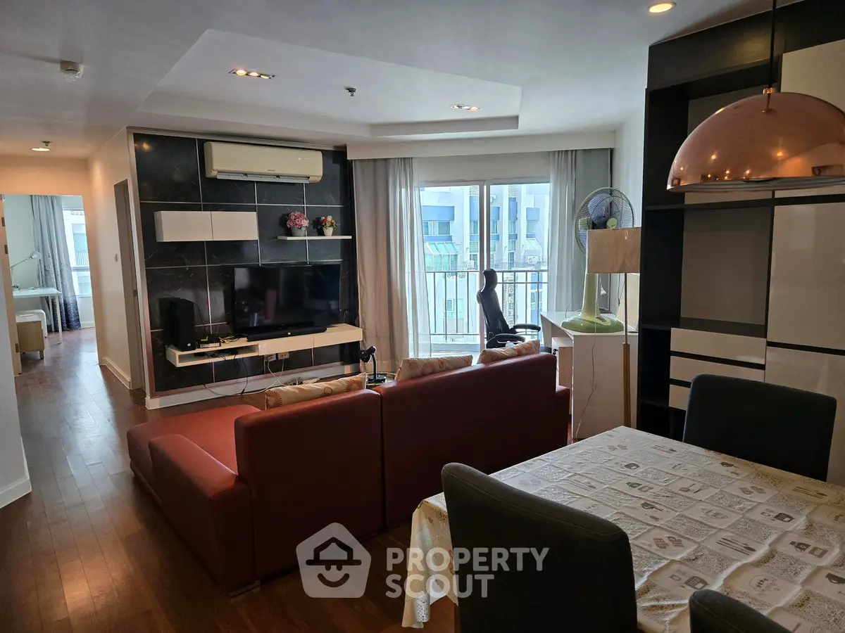 Spacious living room with modern decor and large windows in a stylish apartment.