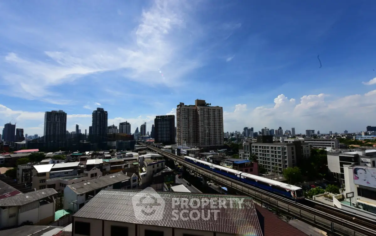 Stunning cityscape view with modern high-rise buildings and a train line under a clear blue sky.