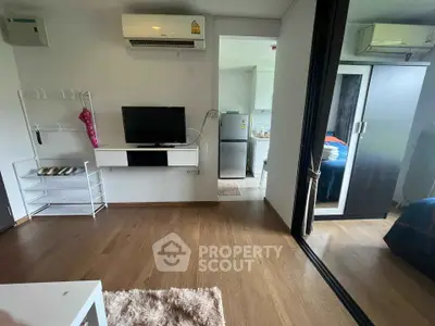 Modern apartment interior with wooden flooring, air conditioning, and sleek furniture design.
