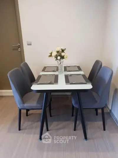 Modern dining area with elegant table setting and stylish chairs in a cozy apartment.