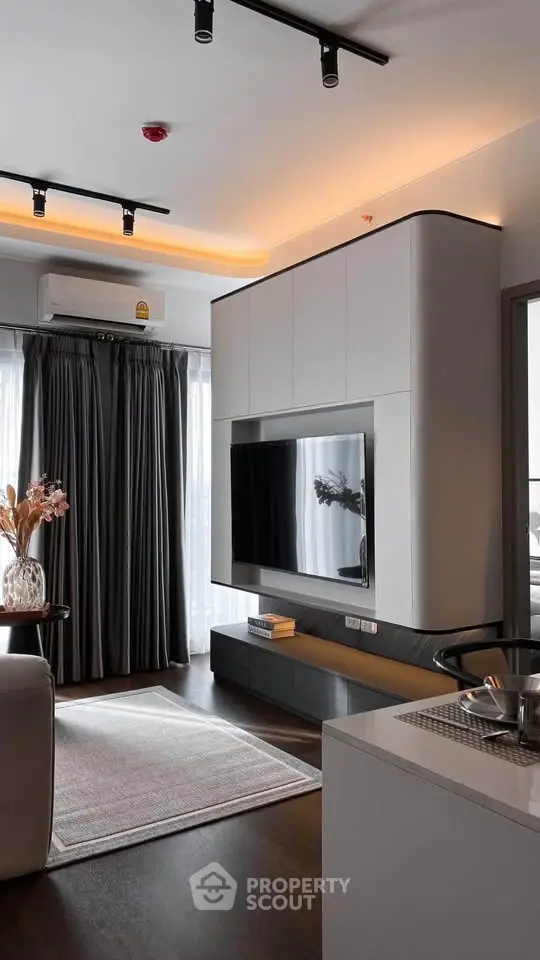 Modern living room with sleek TV unit and elegant lighting in a stylish apartment.