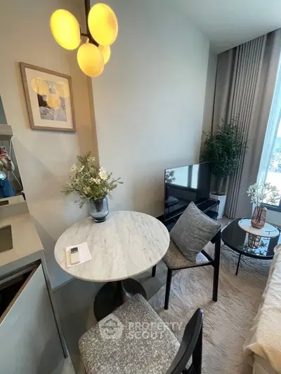 Cozy living room with modern decor, featuring a marble table, stylish lighting, and a large window view.