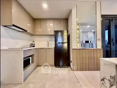 Modern kitchen with sleek cabinetry and stainless steel appliances in a stylish apartment.