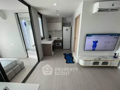 Modern studio apartment with open layout, featuring a compact kitchen and stylish decor.