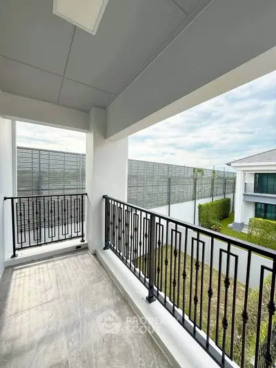 Spacious balcony with elegant railing and scenic view in modern residential building.