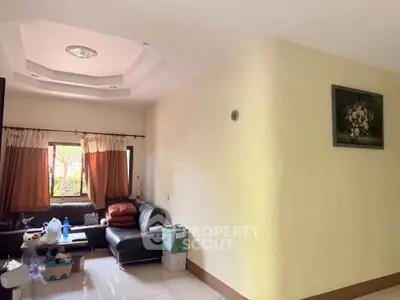 Spacious living room with cozy seating and natural light, perfect for relaxation and entertaining.