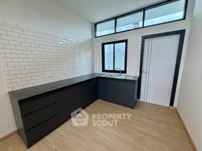 Modern kitchen with sleek black cabinetry and white subway tiles