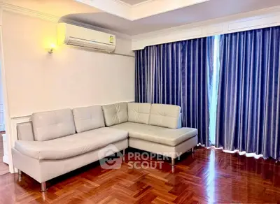 Spacious living room with elegant corner sofa and floor-to-ceiling curtains