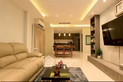 Spacious modern living room with open kitchen and elegant lighting