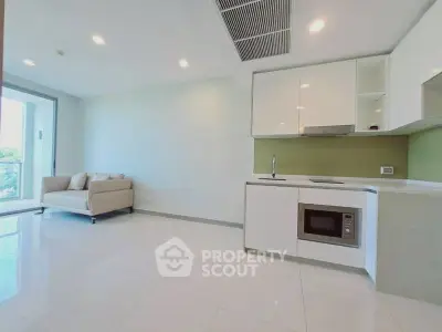 Modern open-layout kitchen with sleek white cabinets and cozy living area, perfect for urban living.