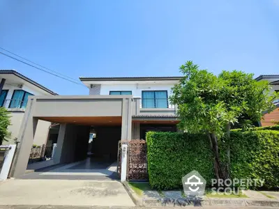 Modern two-story house with lush greenery and spacious driveway