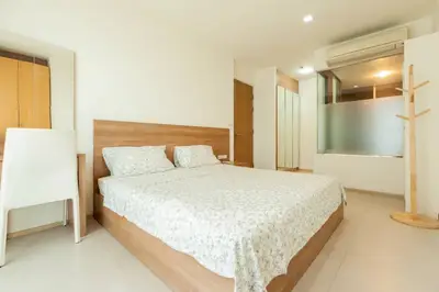 Spacious modern bedroom with minimalist design and ample natural light.