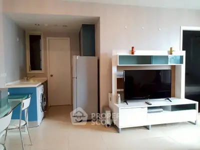 Modern living room with sleek furniture and integrated kitchen appliances in a stylish apartment.