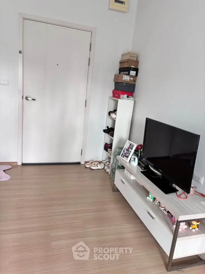 Cozy living room with modern TV stand and wooden flooring, perfect for relaxation.