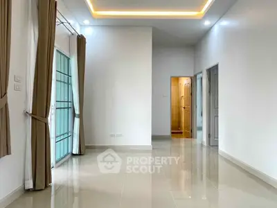 Spacious modern living room with elegant lighting and large windows for natural light.