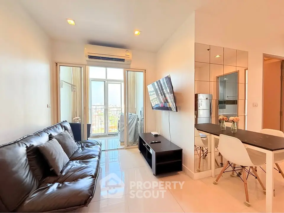 Modern living room with sleek furniture and balcony view in a high-rise apartment.