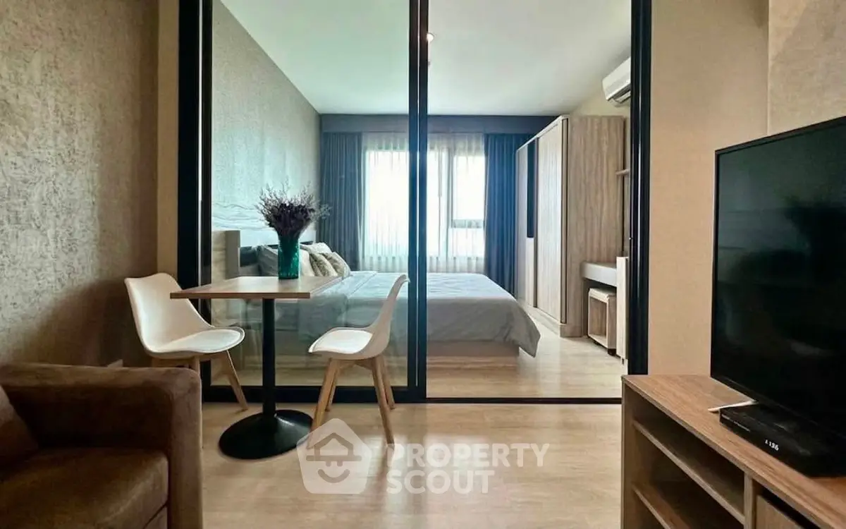 Modern apartment interior with glass partition, cozy bedroom, and stylish dining area.