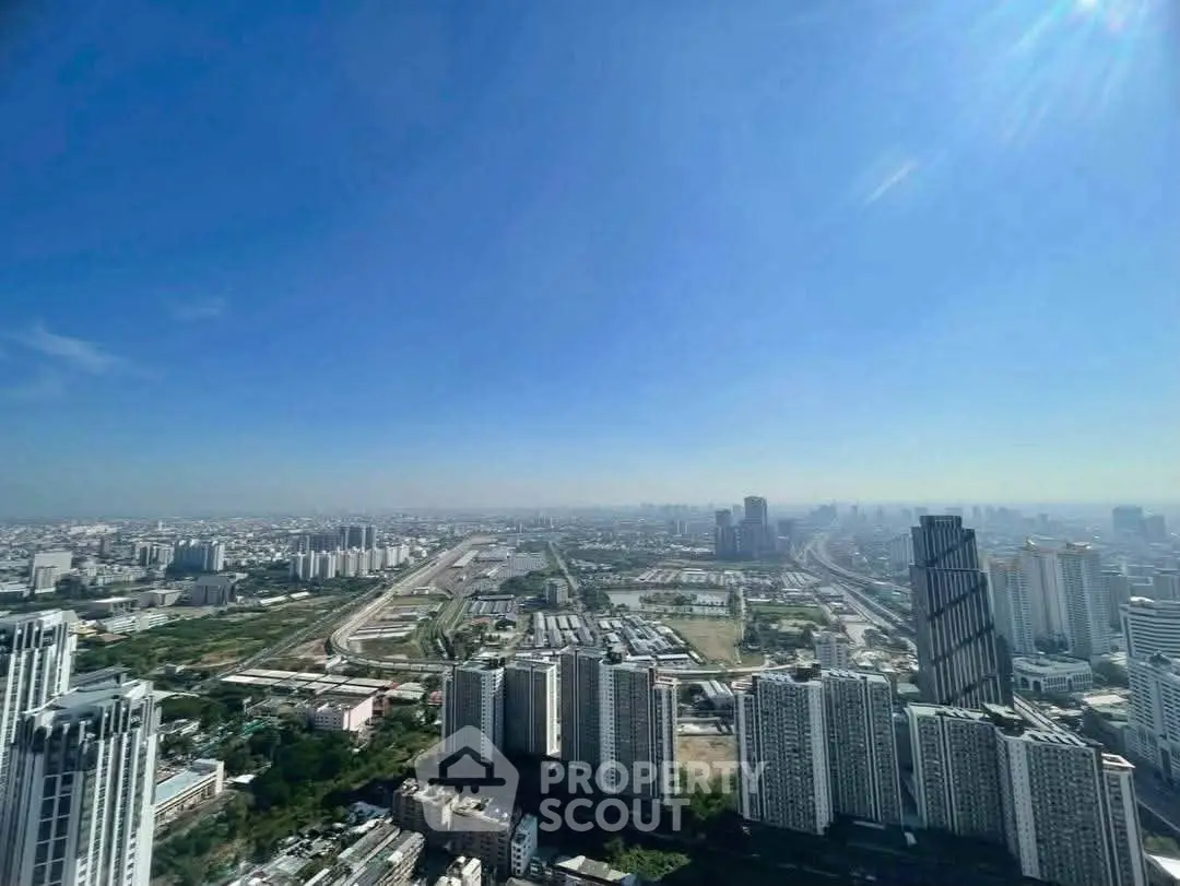 Stunning cityscape view from a high-rise building showcasing urban skyline and clear blue sky.