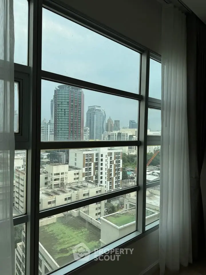 Stunning cityscape view from a high-rise apartment window, showcasing urban skyline and modern architecture.
