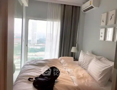 Cozy bedroom with large window and modern decor, offering a serene view.