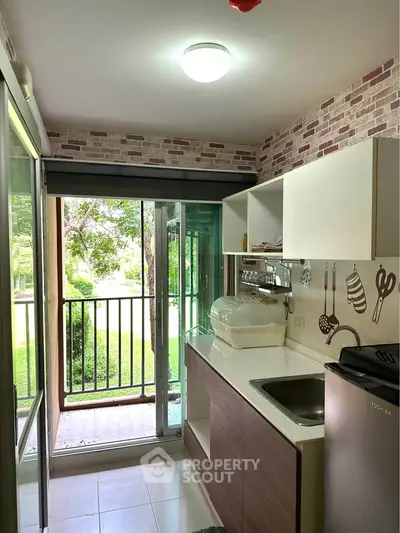 Charming kitchen with balcony view, featuring modern appliances and stylish brick accent wall.
