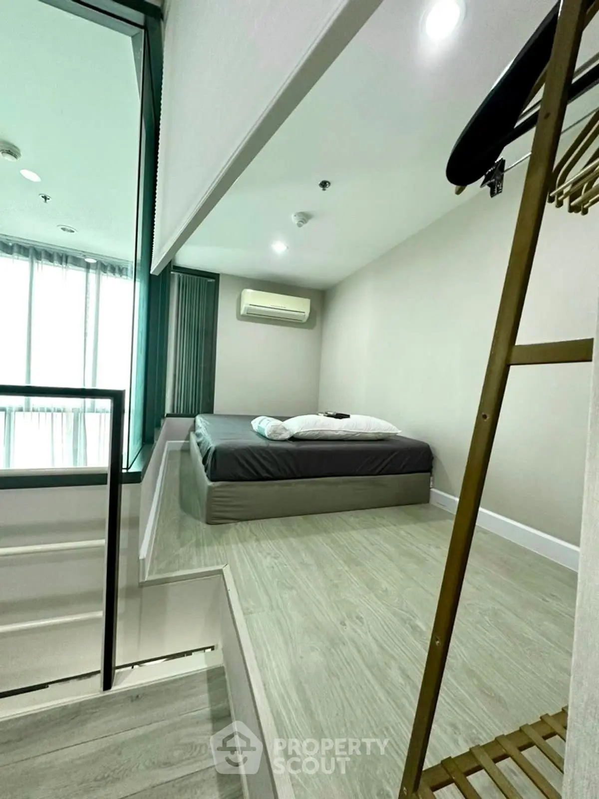 Modern bedroom with minimalist design and large windows for natural light.