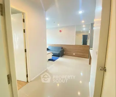 Modern apartment interior with bright hallway leading to cozy living room.