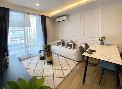 Modern living room with stylish decor and natural light, featuring a cozy seating area and dining space.