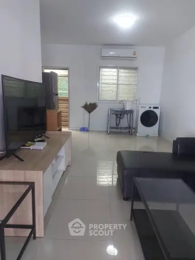 Modern living room with sleek furniture and washing machine, ideal for urban living.