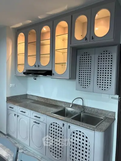 Stylish kitchen with elegant cabinetry and dual sink, perfect for modern living.