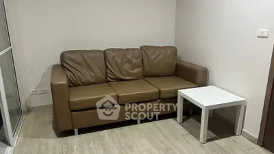 Cozy living room corner with brown leather sofa and white side table