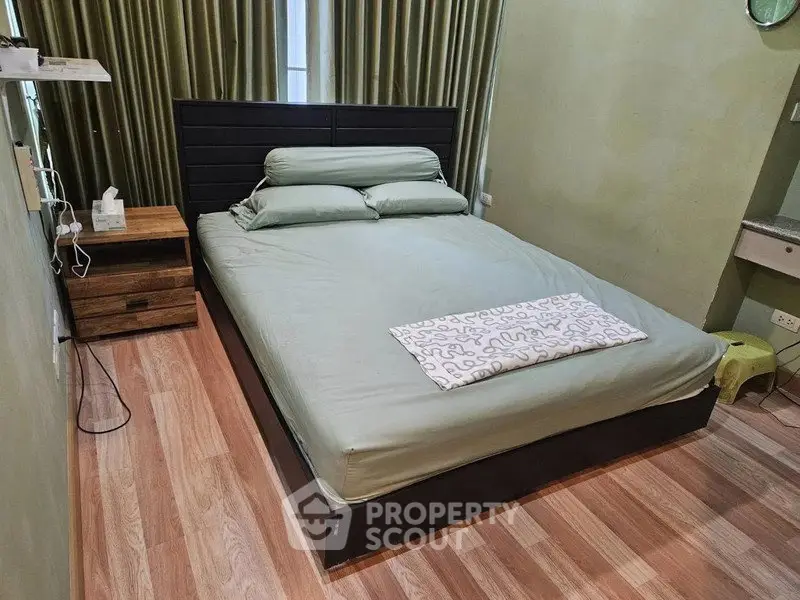 Cozy bedroom with modern decor and wooden flooring, featuring a comfortable bed and stylish side table.
