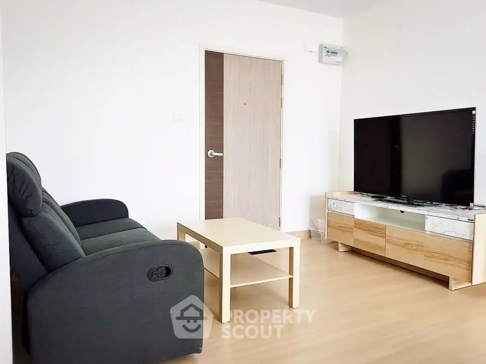 Modern living room with sleek furniture and flat-screen TV, perfect for relaxation and entertainment.