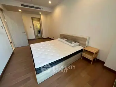 Spacious bedroom with modern wooden flooring and minimalist decor