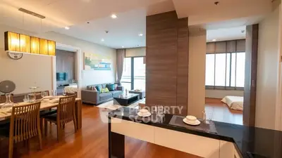Spacious modern living room with dining area and large windows in a stylish apartment.