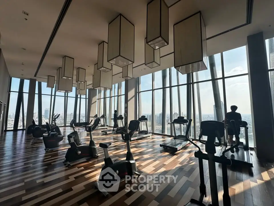 Luxurious high-rise gym with panoramic city views and modern fitness equipment.