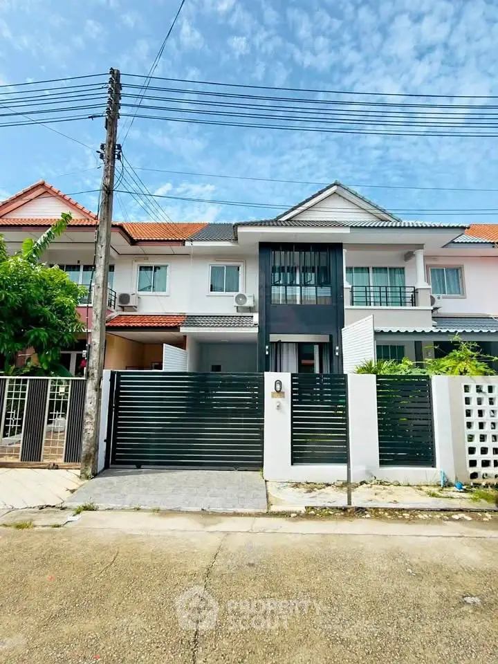 Charming townhouse with modern facade and gated entrance in a serene neighborhood.