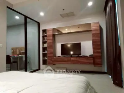 Modern bedroom with sleek TV unit and glass partition for study area