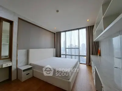 Spacious bedroom with city view, modern furnishings, and ample natural light.